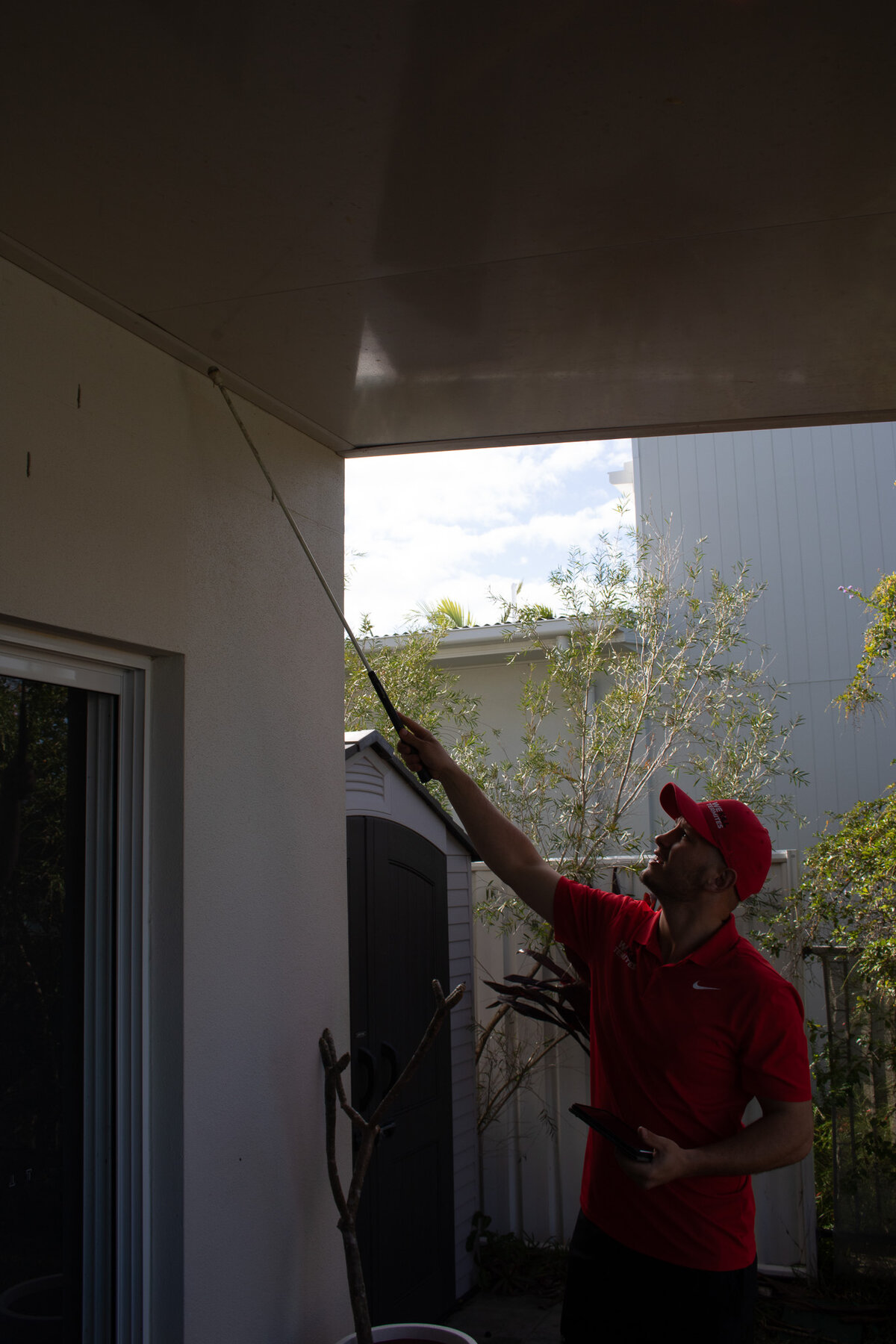 We Kill Termites technician inspecting roof eaves for termite activity